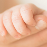 Baby holding finger