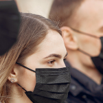 Three people wearing black face masks