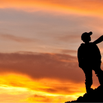 Man and boy on summit at sunset