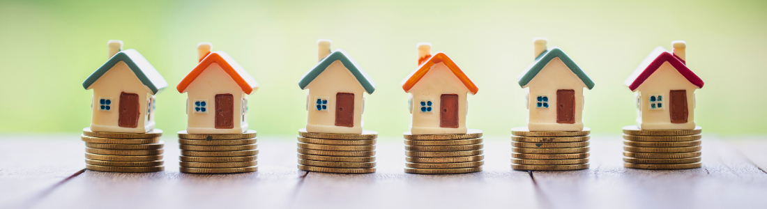 Toy houses standing on coins