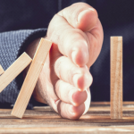 Hand preventing dominoes tumbling