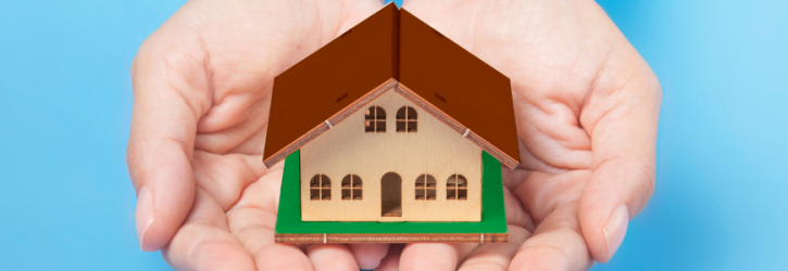 Cupped hands giving small house away
