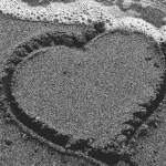 Heart in the sand washing away
