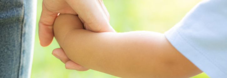 Child and parent holding hands