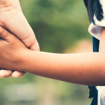 Parent holding child's hand